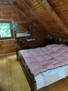 um quarto com uma cama num chalé de madeira em Kuca u sumi em Bijelo Polje
