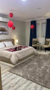 Un dormitorio con una cama con globos rojos. en لورينا شالية, en Al Hofuf