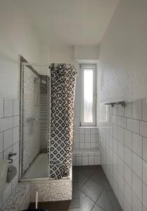 a white bathroom with a tub and a window at Hotel Breuer in Hamm