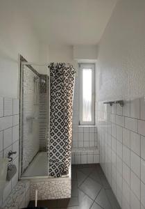 La salle de bains blanche est pourvue d'une baignoire et d'une fenêtre. dans l'établissement Hotel Breuer, à Hamm
