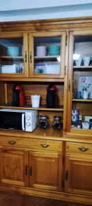 a wooden cabinet with a microwave in it at Finca Rural La Casa Verde Shalom Tenerife in Las Lagunas