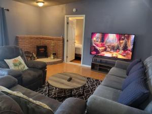 a living room with a couch and a flat screen tv at Sun Angel House #2 Pahrump in Pahrump