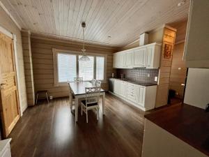 a kitchen with a table and a dining room at Villa Wilhelmiina,LaatuLomat in Juva