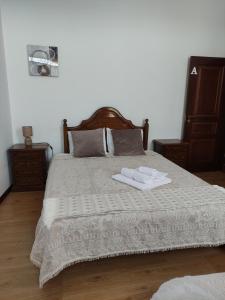 a bedroom with a bed with two towels on it at casa cardeal saraiva in Ponte de Lima