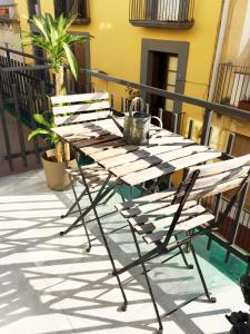 een houten tafel en stoel op een balkon bij MODERNO APARTAMENTO EN EL CENTRO in Vilanova i la Geltrú