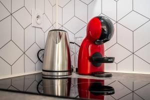 a red appliance sitting on a counter in a kitchen at Un refuge douillet et moderne au cœur d'Audincourt in Audincourt