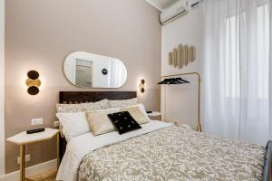 Schlafzimmer mit einem Bett und einem Wandspiegel in der Unterkunft BDC - The Choice, your 2-Bdr apt in Vatican district in Rom