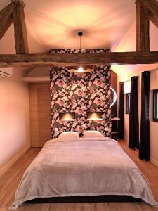 ein Schlafzimmer mit einem großen Bett und einer Steinmauer in der Unterkunft La bergerie cosy - Sauna et bain nordique privatif in Saint-Denis-de-Jouhet
