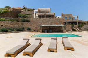a swimming pool with two lounge chairs and a house at Petra House Kea 12776742 in Koundouros