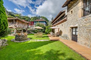 a garden with a table and chairs and a building at Amaicha Hotel Rural in Ribadesella