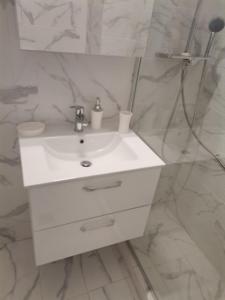 a bathroom with a white sink and a mirror at S & K Apartment free indoor parking in Athens +28 photos
