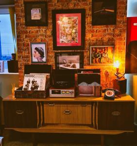 una mesa con radio y fotografías en una pared de ladrillo en The Mercury, Blackpool - over 21's only en Blackpool