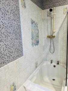 a white bathroom with a tub and a shower at Treetops - Sleeps 8 entire house private parking close to town centre and stadium in Wigan