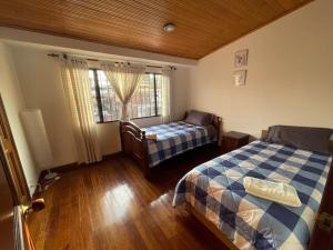 1 dormitorio con 2 camas y ventana en Casa Linda, en Bogotá