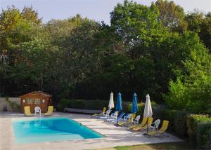 - un groupe de chaises longues et de parasols ainsi qu'une piscine dans l'établissement Roquecombe, à La Roque-Gageac