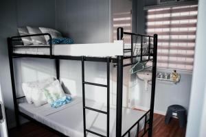 Zimmer mit 2 Etagenbetten und einem Waschbecken in der Unterkunft Olive Hostel Roxas City in Roxas City