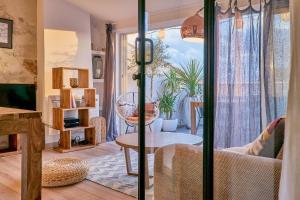 a living room with a table and a glass door at Truchet Penthouse in Arles