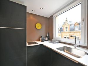 une cuisine avec un évier et une grande fenêtre dans l'établissement Limpersberg - Amazing and cozy flat, à Luxembourg