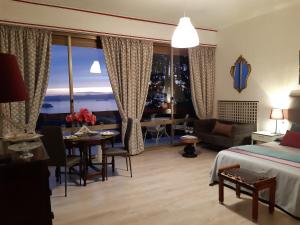 a hotel room with a bed and a dining room at Belvedere del Lago in Montefiascone