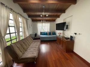 sala de estar con sofá y TV en Casa Linda, en Bogotá