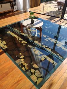 a glass floor with a table and rocks in a room at Cabana Mundo Novo in Gonçalves