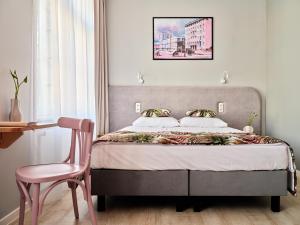 1 dormitorio con 1 cama y 1 silla rosa en HOLA GDYNIA en Gdynia