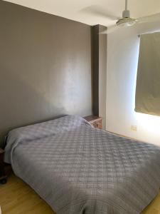 1 dormitorio con 1 cama con edredón gris en Hermoso dúplex interno en la mejor zona de Mendoza en Mendoza
