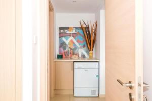 a washer and dryer in a hallway with a painting at LAILA - Coralli Beachfront Apartment in Protaras