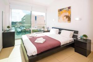 a bedroom with a large bed with two towels on it at LAILA - Coralli Beachfront Apartment in Protaras +39 photos