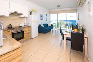 een keuken en een woonkamer met een tafel en een bank bij GABRIELA - Beachfront Apartment in Protaras