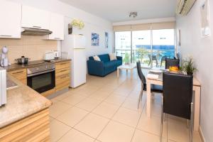 a kitchen and living room with a table and a couch at GABRIELA - Coralli Beachfront Apartment in Protaras