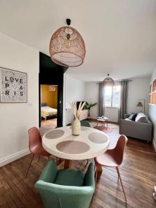 een woonkamer met een tafel en stoelen bij Casa Paris - Paisible & Central T2 - Coeur de Brive - 4 Personnes in Brive-la-Gaillarde