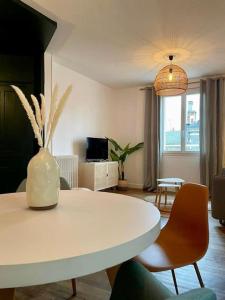 een woonkamer met een witte tafel en stoelen bij Casa Paris - Paisible & Central T2 - Coeur de Brive - 4 Personnes in Brive-la-Gaillarde