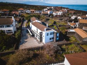 einem Luftblick auf ein Dorf mit einem weißen Haus in der Unterkunft Casa das Ondas in São Roque do Pico