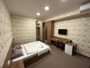 a bedroom with a bed and a desk and a television at 5 Rooms near 300 Aragveli metro station in Tbilisi City