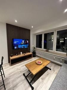 a living room with a table and a tv at Amazing cosy flat Lux Gare in Luxembourg