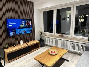 a living room with a flat screen tv and a coffee table at Amazing cosy flat Lux Gare in Luxembourg