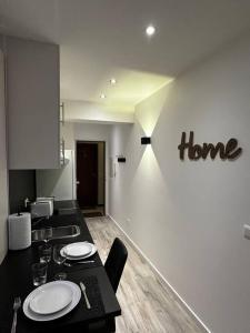 a kitchen with a table and a home sign on the wall at Amazing cosy flat Lux Gare in Luxembourg