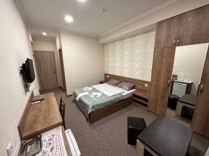 una camera d'albergo con letto e scrivania di 5 Rooms near 300 Aragveli metro station a Tbilisi City