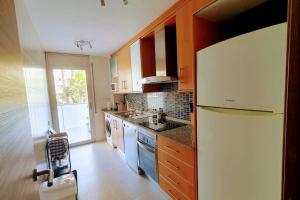 eine Küche mit einem weißen Kühlschrank und einer Spüle in der Unterkunft Eden Flat Port Aventura in Salou