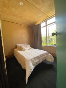 a small bedroom with a bed and a window at Young Hostel in Rotorua