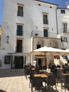 an outdoor patio with tables and umbrellas in front of a building at Casa Cardi in Sperlonga