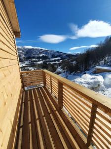 une terrasse en bois avec vue sur une montagne enneigée dans l'établissement Molden 2-fjellutsikt og jacuzzi tilgang., à Luster