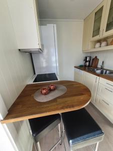 uma pequena cozinha com uma mesa de madeira e cadeiras em Molden 2-fjellutsikt og jacuzzi tilgang. em Luster