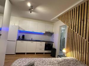 a kitchen with white cabinets and a bed in a room at Amazing Hyper Central Flat- Esch in Esch-sur-Alzette