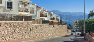 a stone wall next to a street with houses at Apartment Amdar Village עם ממ"ד in Eilat