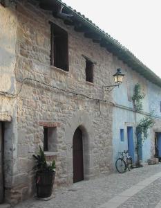 un antiguo edificio de piedra con una bicicleta estacionada al lado en Casa Nemesio, enclave y vistas excepcionales en Valderrobres