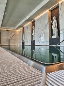 - un hall avec des murs en marbre et des statues sur le mur dans l'établissement Spa Resort Libverda - Hotel Lesní Zátiší, à Lázně Libverda