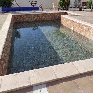 una piscina con una pared de piedra y una piscina en Studio Meublé non fumeur, en Narbona