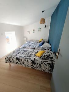 1 dormitorio con 1 cama con edredón blanco y negro en Gîte Ambroise (proche Puy du fou), en La Petite-Boissière